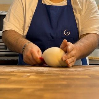 Una persona che indossa un grembiule con la lettera g sopra