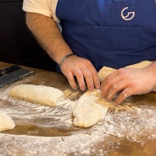 Un uomo che indossa un grembiule blu con la lettera g sopra