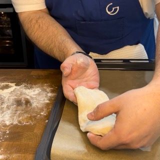 Una persona che indossa un grembiule blu con la lettera g sopra