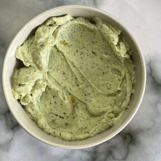 Una ciotola di salsa verde è appoggiata su un tavolo.