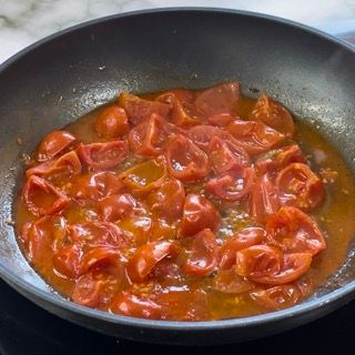 Una padella piena di pomodori e salsa