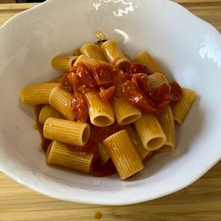 Una ciotola bianca piena di pasta e salsa di pomodoro