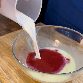 Una persona sta versando il latte in una ciotola di liquido