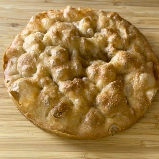 Una torta è appoggiata su un tagliere di legno.