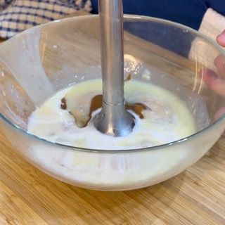 Una persona sta mescolando qualcosa in una ciotola con un frullatore