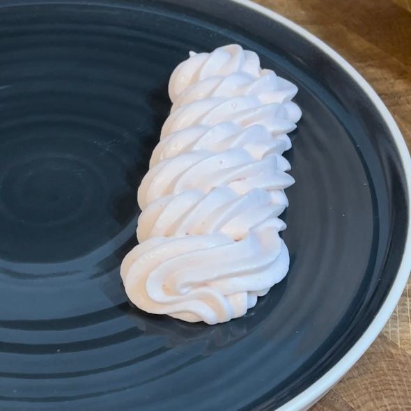 Un pezzo di panna montata su un piatto nero