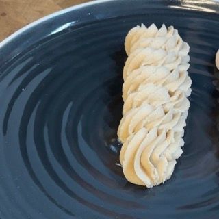 Un piatto blu con sopra della panna montata