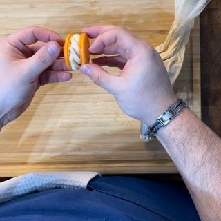 Una persona che indossa un orologio tiene un panino tra le mani