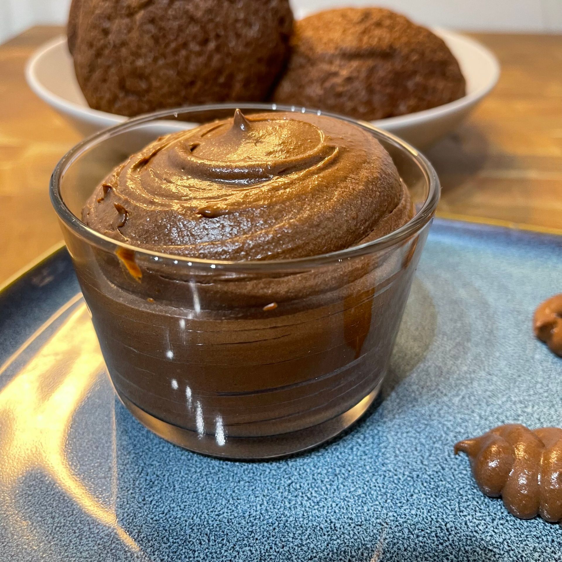 Una ciotola di mousse al cioccolato su un piatto blu