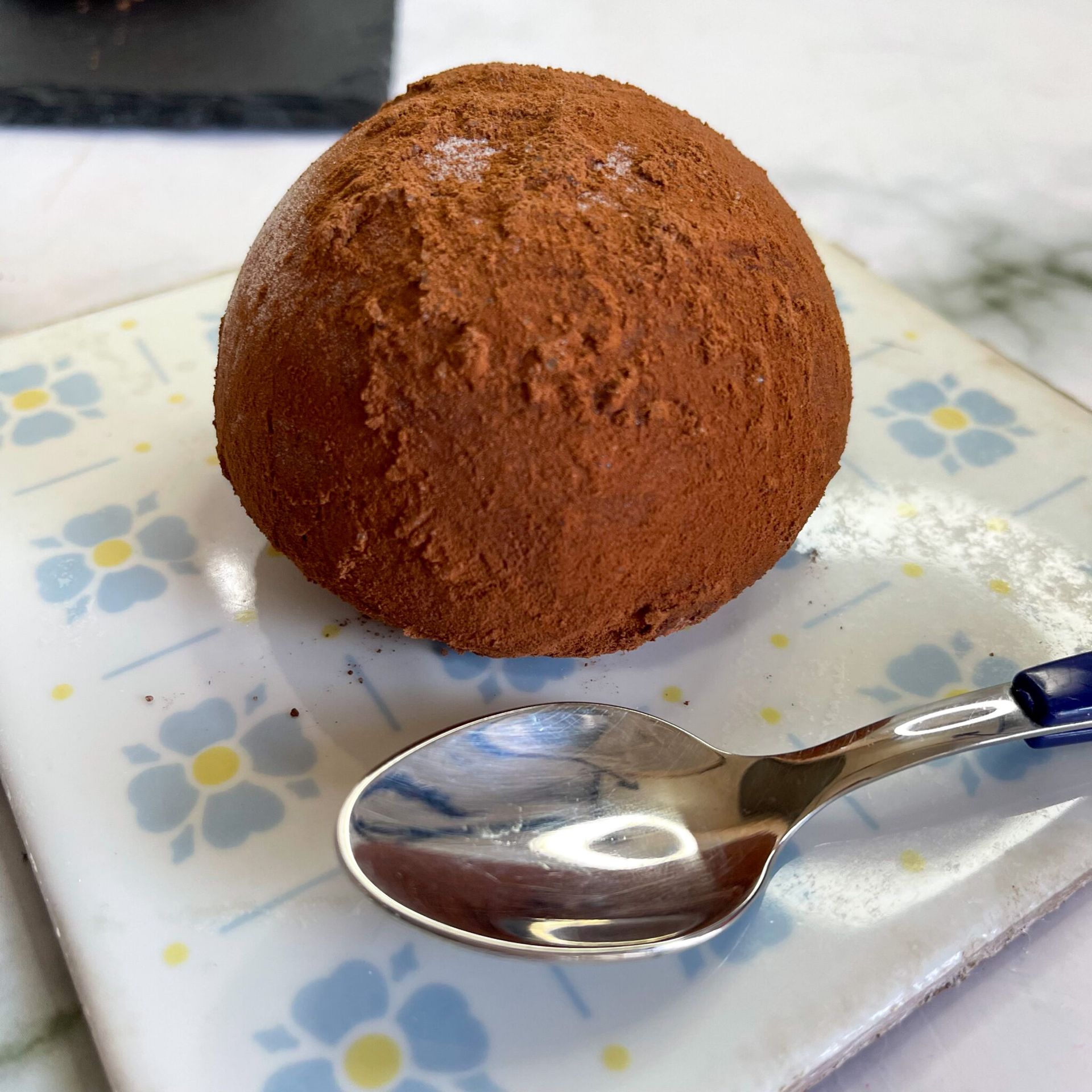 Una pallina di cioccolato su un piatto con un cucchiaio