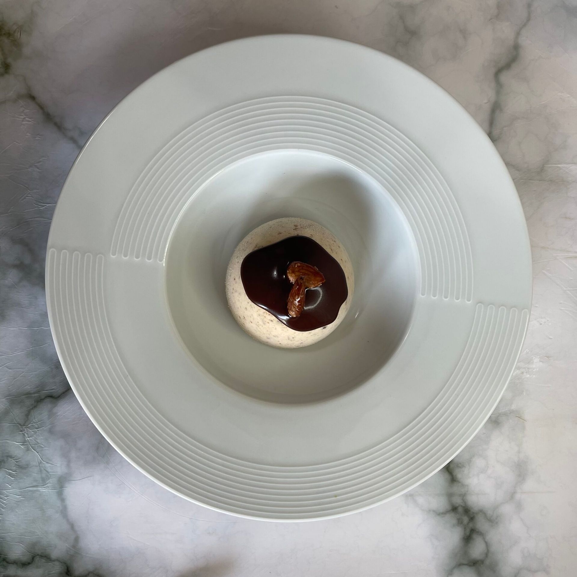 Un piatto bianco con un piccolo dessert sopra