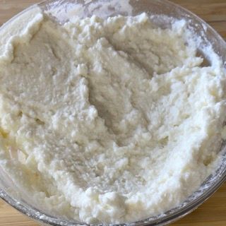 Una ciotola di purè di patate è appoggiata su un tavolo di legno.