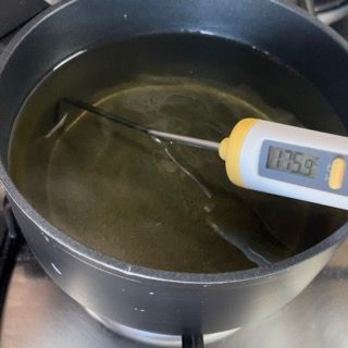 Un termometro digitale è posizionato in una pentola di liquido