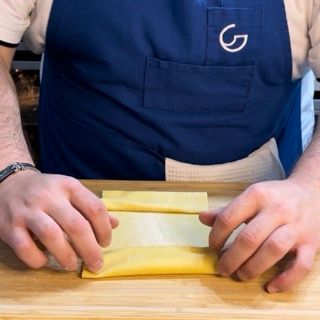 Un uomo che indossa un grembiule con la lettera g sopra