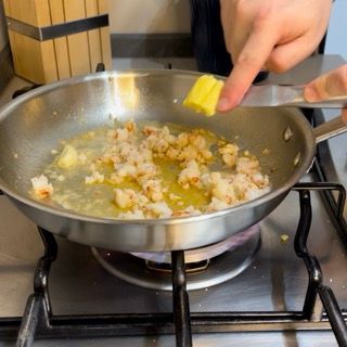 Una persona sta cucinando del cibo in una padella su un fornello