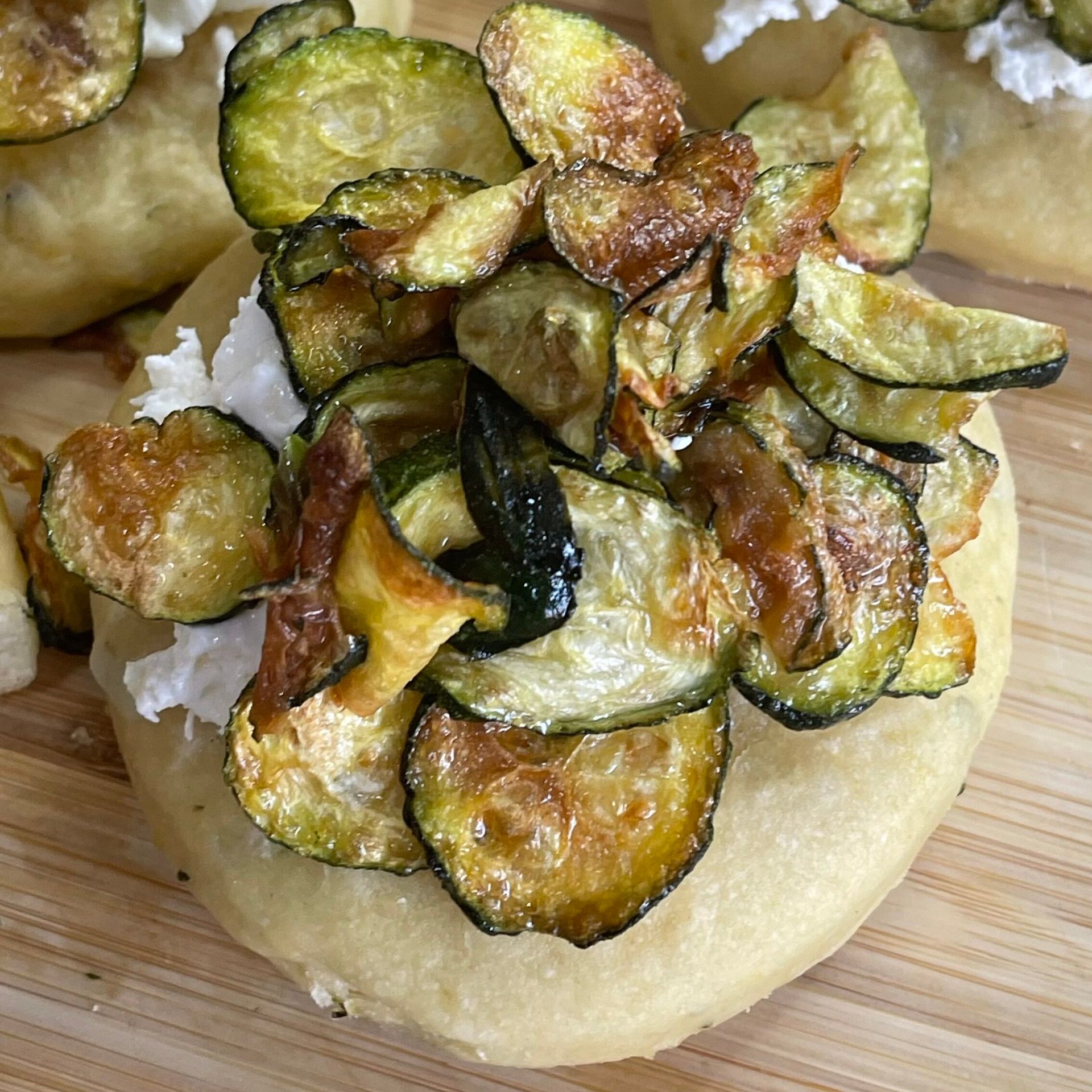 Un primo piano di una pizza con verdure sopra su un tavolo di legno.