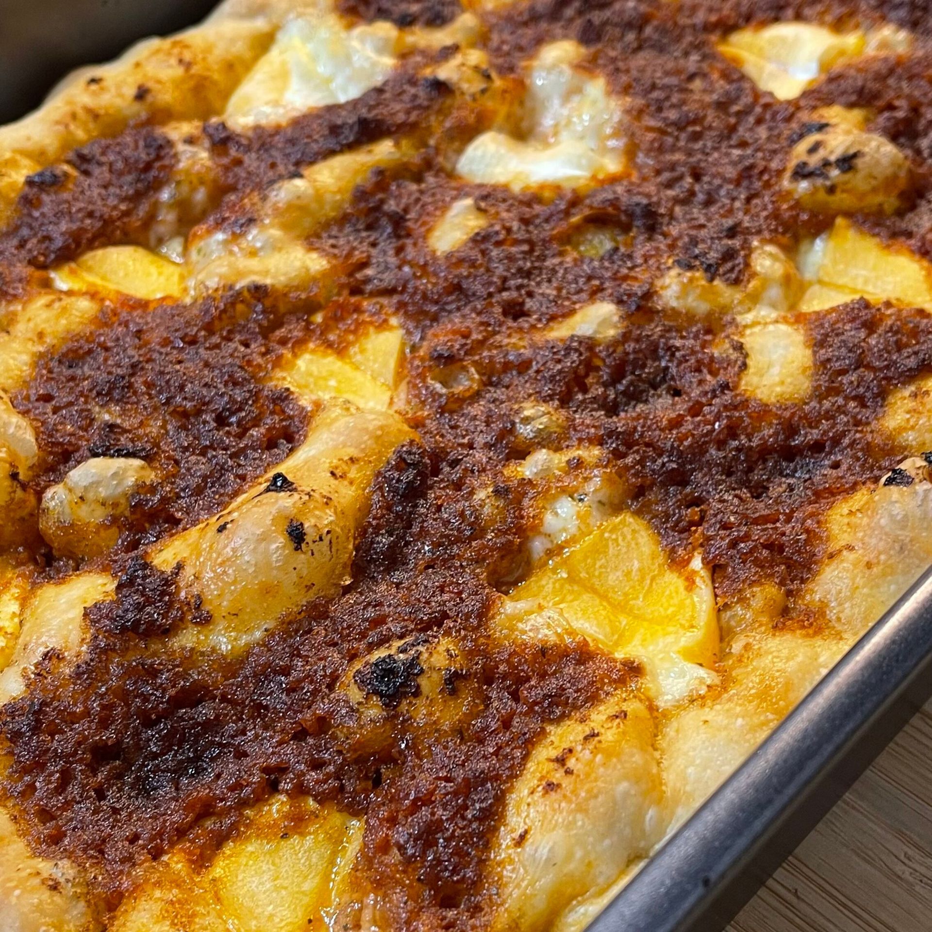 Un primo piano di una pizza in padella su un tavolo.