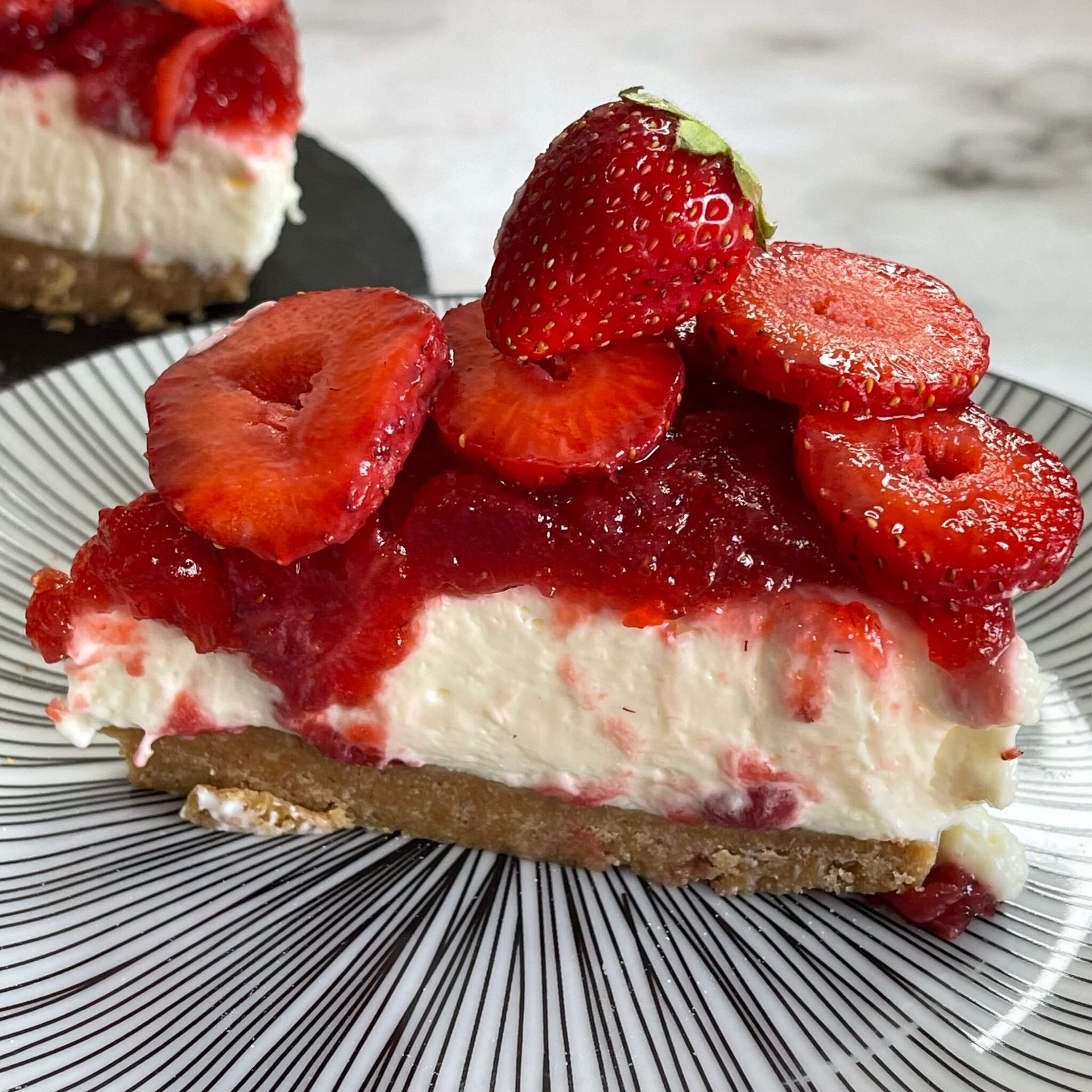 Una fetta di cheesecake con fragole sopra su un piatto.