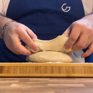 Una persona che indossa un grembiule con la lettera g sopra