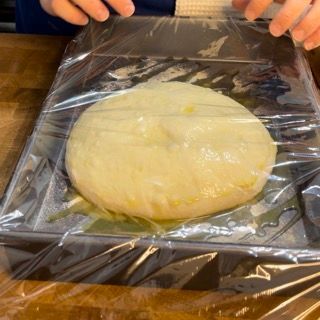 Una persona sta avvolgendo un pezzo di pasta nella pellicola trasparente