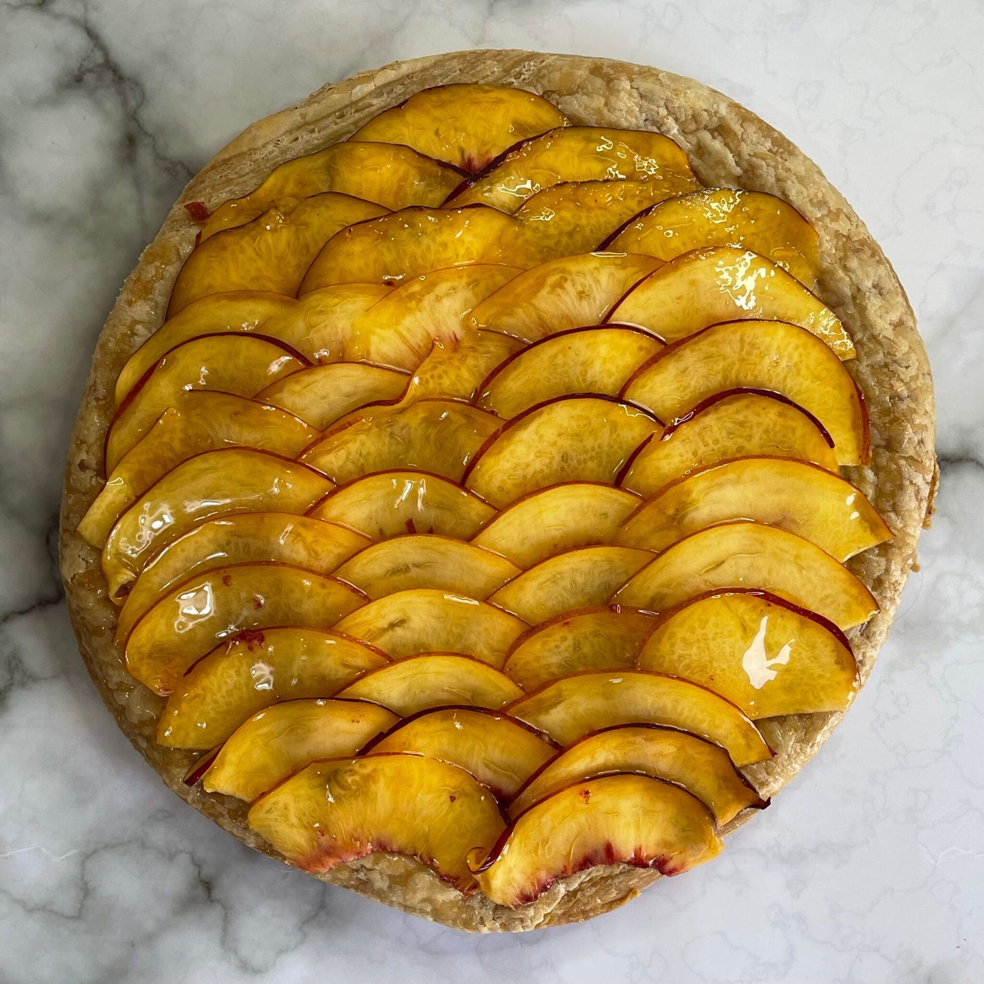 Una torta con sopra delle fette di pesche