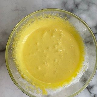 Primo piano di una ciotola di liquido giallo su un tavolo.