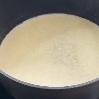Primo piano di una pentola piena di un liquido bianco.
