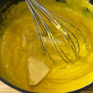 Una frusta è in una ciotola di liquido giallo