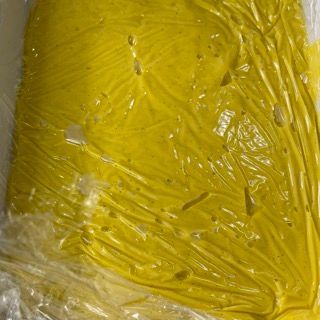 Primo piano di una sostanza gialla avvolta nella plastica.