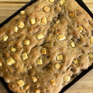 Una pagnotta di pane è appoggiata su un tavolo di legno.