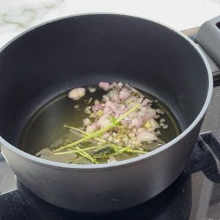 Una pentola piena di verdure e olio sul fornello