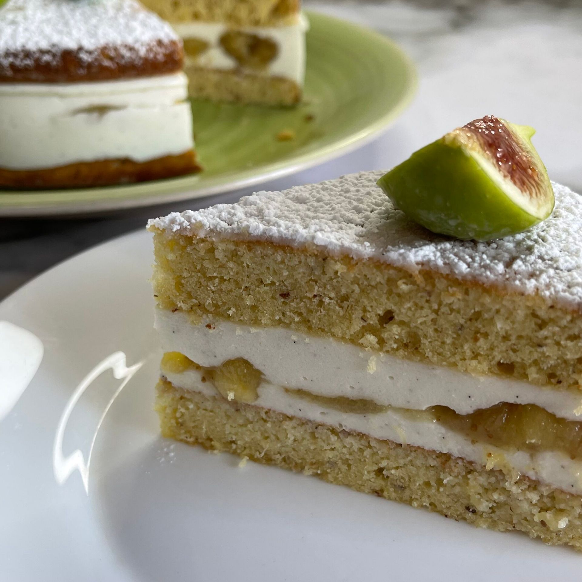 Una fetta di torta con zucchero a velo e un fico sopra