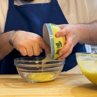 Una persona sta versando qualcosa in una ciotola di vetro
