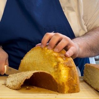 Una persona sta tagliando un pezzo di pane su un tagliere