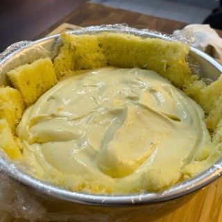 Una ciotola di purè di patate è appoggiata su un tavolo di legno.