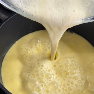 Crema pasticcera che si addensa in un pentolino sul fuoco