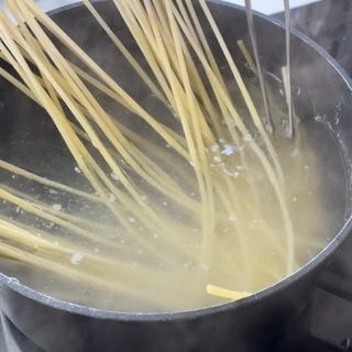 Spaghetti che cuociono in abbondante acqua bollente.