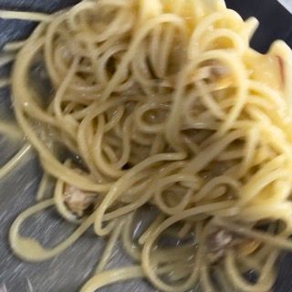 Mantecatura finale degli spaghetti alle vongole con olio a crudo e prezzemolo.