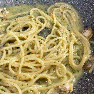 spaghetti alle vongole cremosi serviti in un piatto fondo.