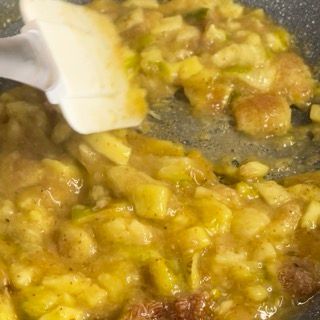Si usa una spatola per mescolare una salsa gialla in una padella.