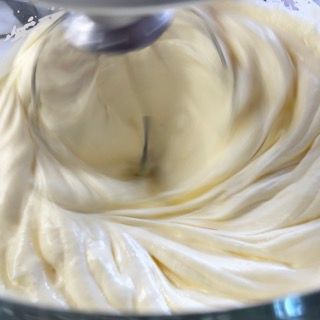 Un primo piano di un mixer con panna montata al suo interno.