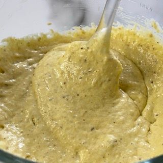 Si usa un cucchiaio per mescolare un liquido giallo in una tazza graduata.