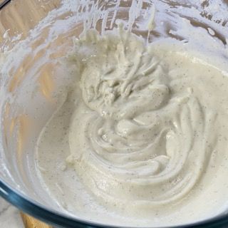 Primo piano di una ciotola di vetro piena di liquido bianco.