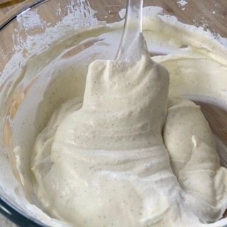 Un cucchiaio spunta da una ciotola di panna montata.