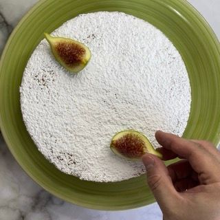 Un piatto verde condito con zucchero a velo e fichi
