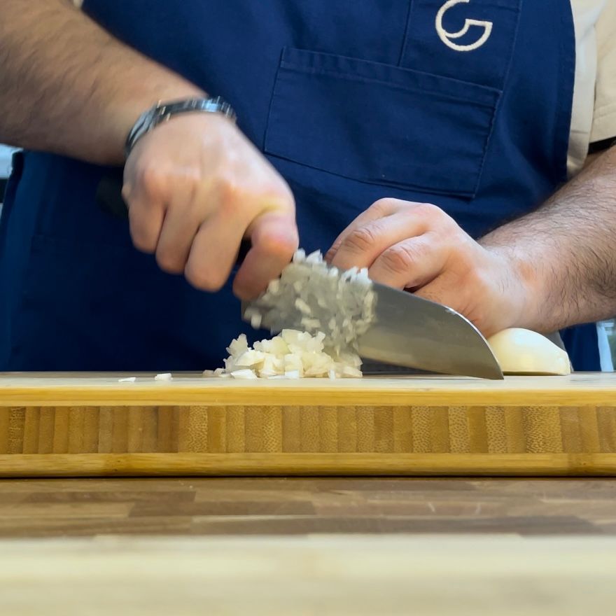 Coltello che trita finemente la cipolla per il ragù.