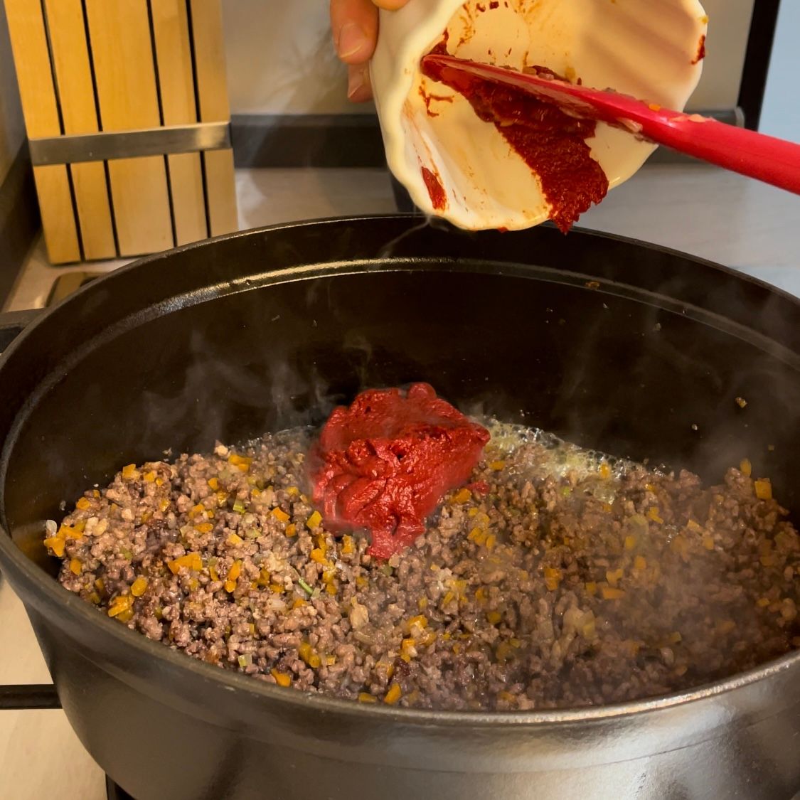 Concentrato di pomodoro  versato nel ragù.