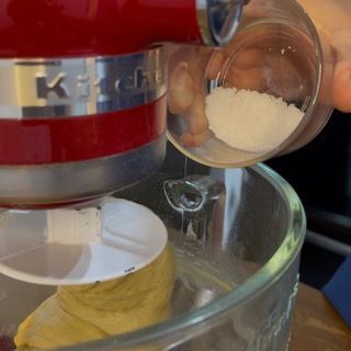 Una persona che versa qualcosa in un mixer KitchenAid
