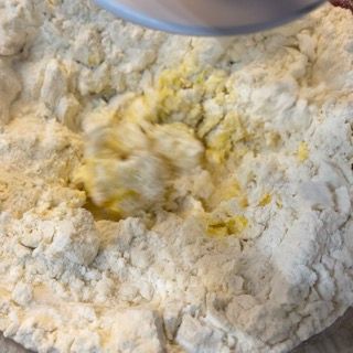 Latte versato a filo nell'impasto dei cinnamon rolls.