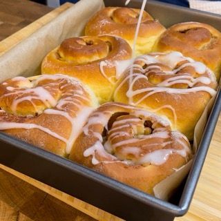 Apple cinnamon rolls tiepidi, coperti da una colata di glassa allo yogurt.